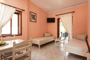 a living room with two beds and a table at Alykes Park Bungalows in Alykes
