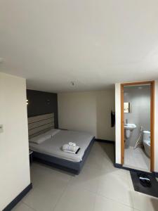 a bedroom with a bed and a sink and a toilet at Nice Hotel Monumento in Manila