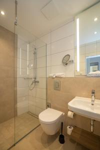 a bathroom with a shower and a toilet and a sink at Hotel Union Salzwedel in Salzwedel +43 photos