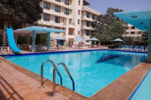 a large swimming pool with a slide in front of a hotel at Beach Luxury Hotel in Karachi