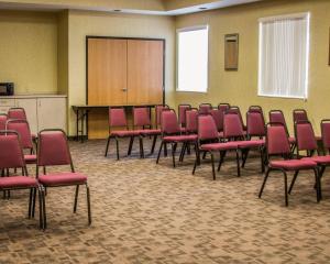 a conference room with red chairs and a podium at Comfort Inn Birch Run - Frankenmuth in Birch Run