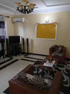 a living room with a couch and a table at Palace Ndogbong Bifaga in Bassa