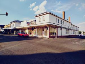 a red car parked in front of a white building at Heidelberg Crown Hotel in Heidelberg
