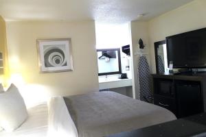 a hotel room with a bed and a flat screen tv at Quality Inn McComb in McComb