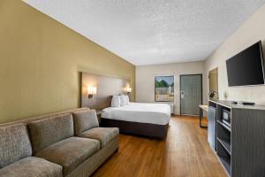 a hotel room with a bed and a couch at Econo Lodge Greenville in Greenville