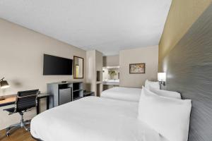 a hotel room with two beds and a desk at Econo Lodge Greenville in Greenville