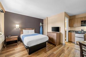 a large bedroom with a bed and a kitchen at Suburban Studios Charlotte - Ballantyne in Charlotte