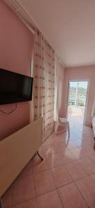 a living room with a flat screen tv on the wall at Yalçın Pansiyon in Silifke +4 photos
