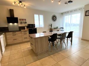 a large kitchen with a table and chairs in it at Maliania in Arbonne +11 photos