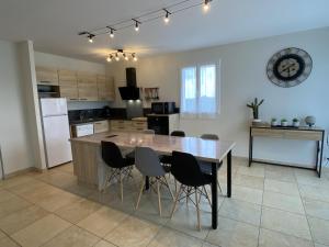 a kitchen with a large wooden table and chairs at Maliania in Arbonne