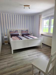 a bedroom with a large white bed in a room at Ferienwohnung MOIN in Osdorf