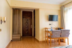 a room with a table and chairs and a door at Nyeri Club in Nyeri