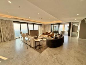 a large living room with couches and tables and windows at The Leonardo in Johannesburg