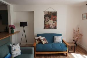 a living room with a blue couch and a table at Garden flat seafront Hastings in Hastings