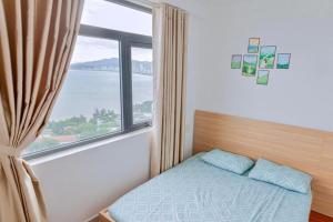 a bedroom with a bed and a large window at Napoleon Apartment Nha Trang - Gần Biển Hòn Chồng in Nha Trang