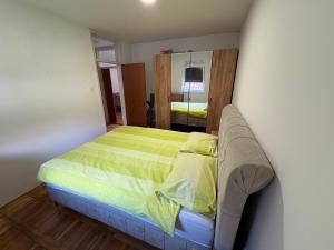 a bedroom with a bed with a yellow blanket at Apartman Ana in Trebinje