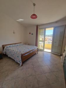 a bedroom with a bed and a sliding glass door at Affittacamere Sofy in Villasimius +12 photos