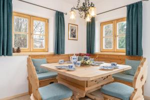 a dining room with a wooden table and chairs at Chalet Vogelnest am Waldbach in Reit im Winkl