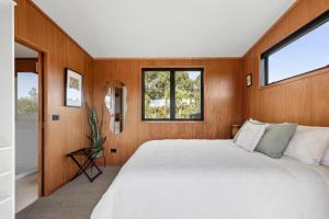a bedroom with a large white bed and two windows at Relaxing Getaway in Pohara in Pohara
