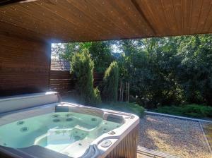 a jacuzzi tub in a backyard with a large window at Virág Vendégház in Hercegkút