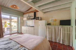 a kitchen with a bed and a refrigerator in a room at Mimosa in La Jarrie