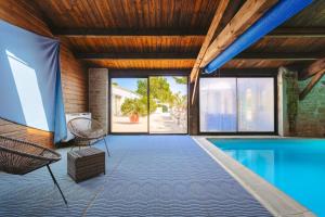 a house with a swimming pool and a wooden ceiling at Mimosa in La Jarrie