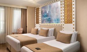 a hotel room with two beds and a painting on the wall at Goms Hotel Old City in Istanbul