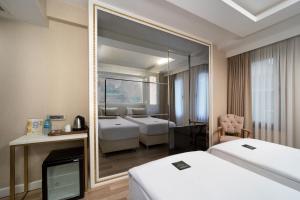 a hotel room with two beds and a mirror at Goms Hotel Old City in Istanbul