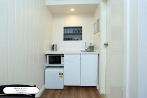 a small kitchen with white cabinets and a microwave at Surf Beach Motel Newcastle in Newcastle