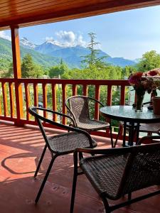 a table and chairs on a deck with a view of mountains at ShodaView in Oni