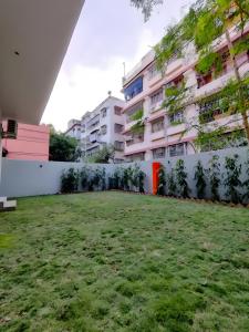 a grassy yard in front of a building at Stay by Insata Hospitality - Kolkata in Kolkata +29 photos