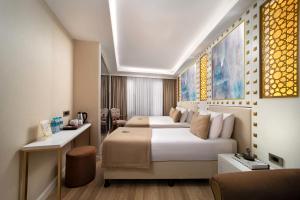 a hotel room with two beds and a desk at Goms Hotel Old City in Istanbul