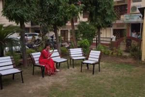 a woman in a red dress sitting on chairs at MAG Hotels in Patna
