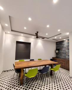 a conference room with a wooden table and green chairs at Stay by Insata Hospitality - Kolkata in Kolkata
