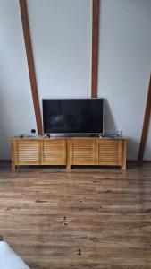 Ein Flachbildfernseher steht auf einem hölzernen Unterhaltungsmöbel. in der Unterkunft Silent A-FRAME in Brăteşti