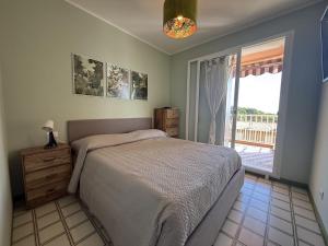 a bedroom with a bed and a large window at Capo d'Arco - Bougainvillea in Capo D'Arco +29 photos
