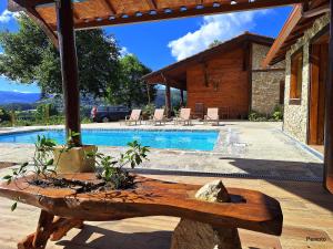 a house with a pool and a wooden table at Casa das Devesas in Caldelas