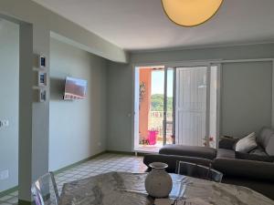 a living room with a table and a couch at Capo d'Arco - Bougainvillea in Capo D'Arco