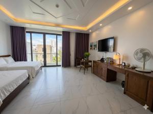 a large hotel room with a bed and a television at MoonKing FLC Sầm Sơn in Sầm Sơn +1 photo