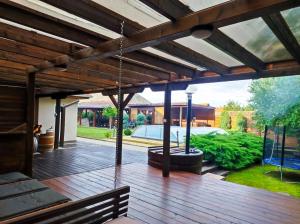 a patio with a wooden deck with a swing at Virág Vendégház in Hercegkút