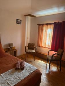 a bedroom with a bed and two chairs and a window at Petite champagne in Germignac