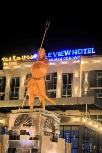 a statue of a man holding a spear on top of a building at Nile View Hotels in Shirih