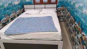 a bed in a room with a painting on the wall at Rk cottage in Rāmeswaram