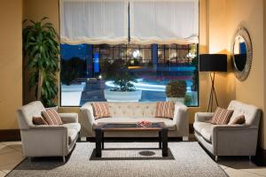 a living room with two couches and a large window at Elba Madrid Alcalá in Madrid