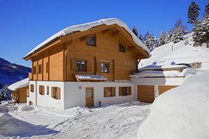 a large wooden house with snow on it at Harrys Chalet in Scharnitz