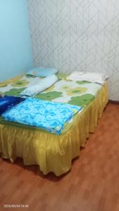 two beds in a room with a yellow blanket on them at Villa Raisya Berastagi in Berastagi