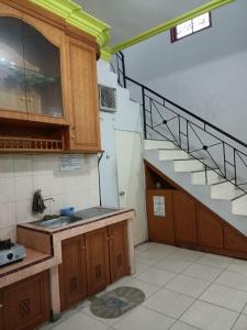 a kitchen with a sink and a staircase at Villa Raisya Berastagi in Berastagi