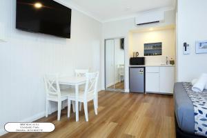 a room with a table and chairs and a kitchen at Surf Beach Motel Newcastle in Newcastle +40 photos