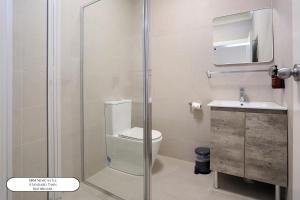 a bathroom with a shower with a toilet and a sink at Surf Beach Motel Newcastle in Newcastle