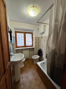 a bathroom with a sink and a tub and a toilet at Il Rifugio Verde in Valle Agricola